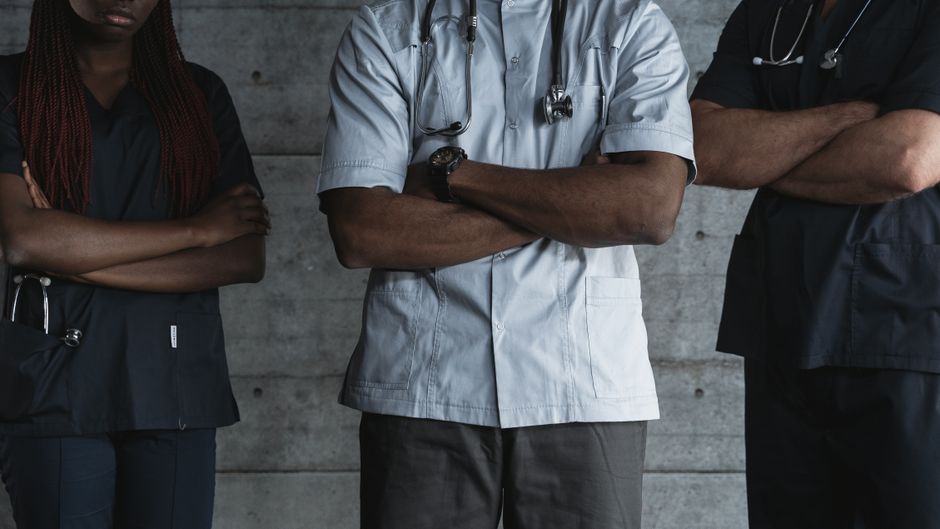 Equipe de consultório médico pequeno organizando a rotina de atendimento