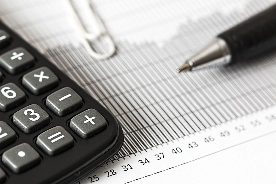 Calculadora e documentos de folha de pagamento sobre a mesa
