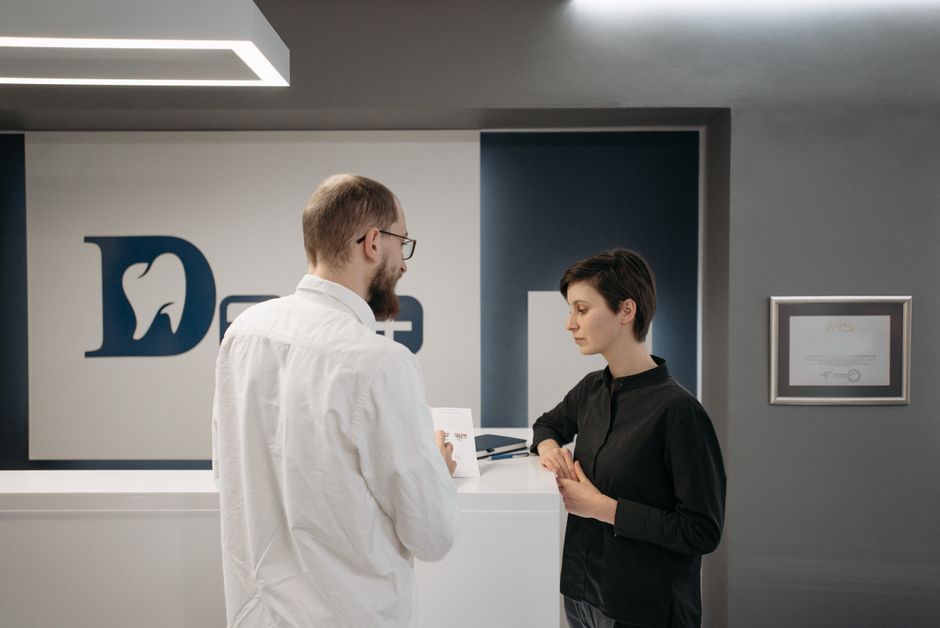 Recepção de clínica odontológica pequena com dentista atendendo paciente