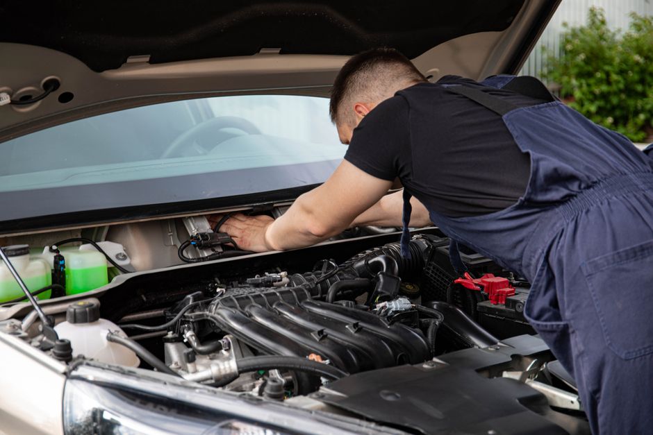 Mecânico realizando manutenção em motor de carro em oficina