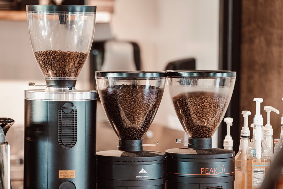Moedores de café cheios de grãos torrados em uma cafeteria