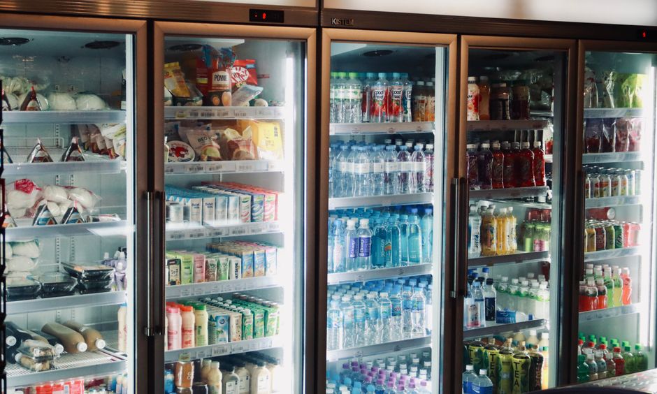 Balcão refrigerado com bebidas e produtos em loja de bairro