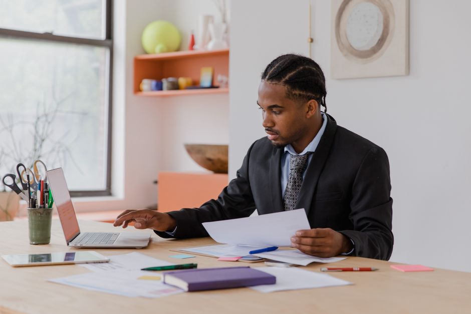 Dono de pequena empresa organizando papelada e contrato no escritório