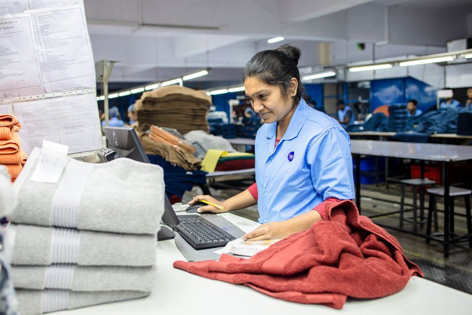 Trabalhadora de fábrica inspecionando produto para controle de qualidade