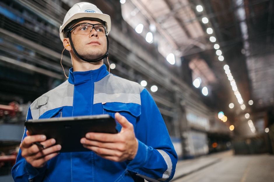 Operária de fábrica usando um tablet no chão de fábrica