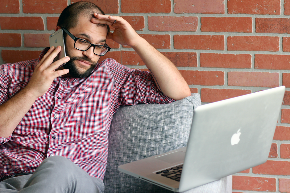 Homem preocupado revisando e-mails no notebook em um escritório