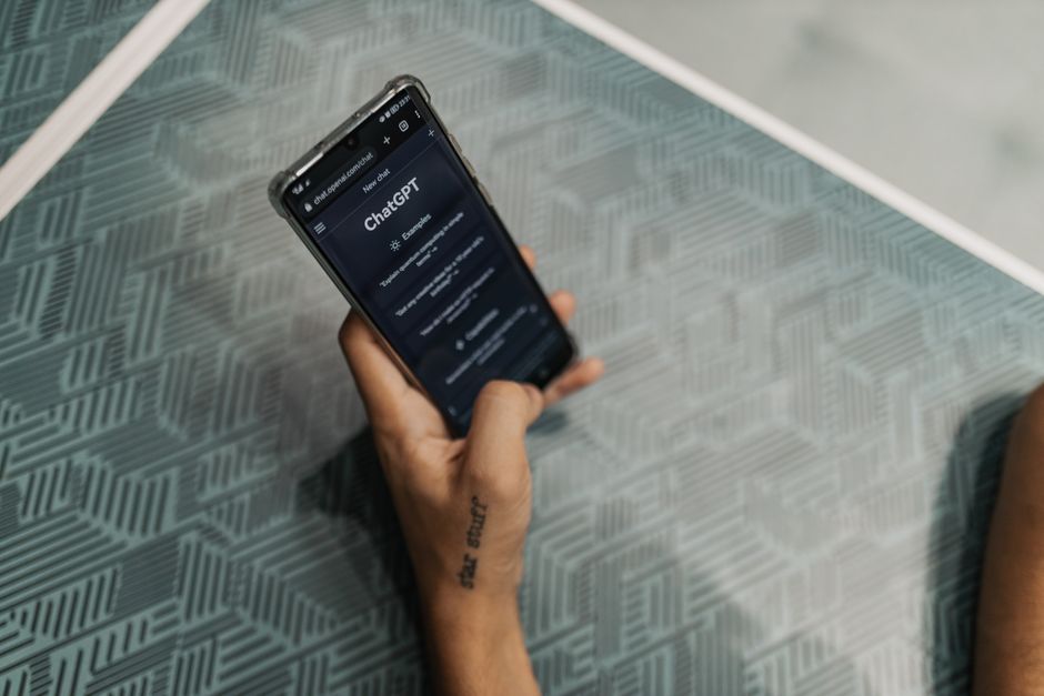 Pessoa segurando smartphone com aplicativo de inteligência artificial aberto