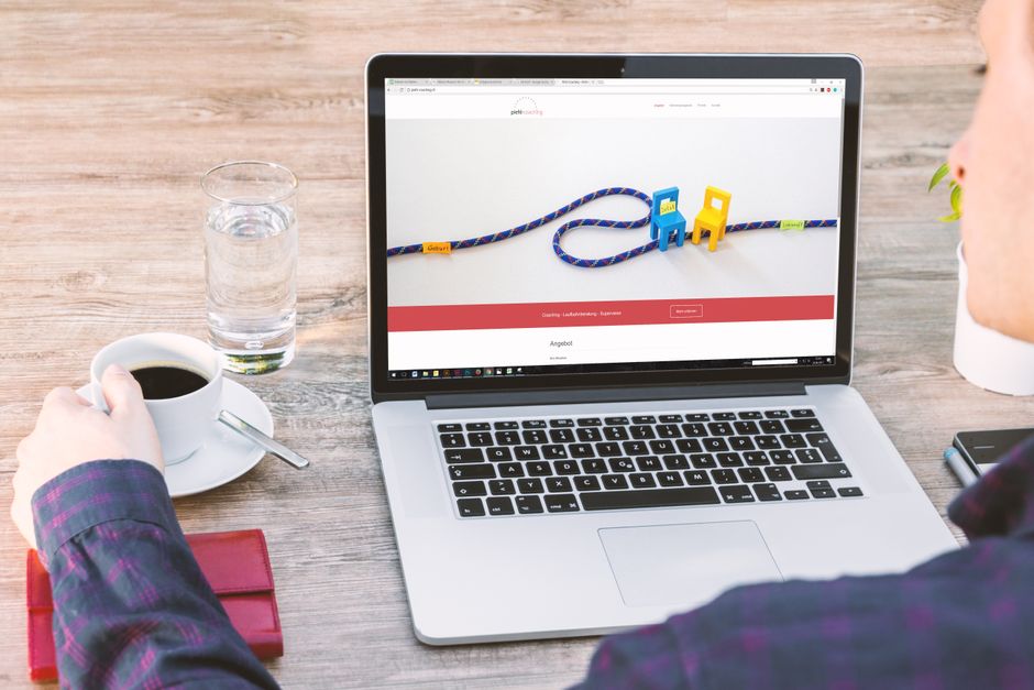 Dono de pequeno negócio trabalhando em notebook com anotações de vendas