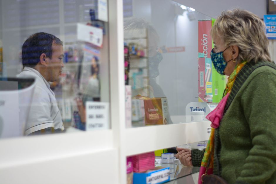 Farmacêutica atendendo cliente no balcão da farmácia