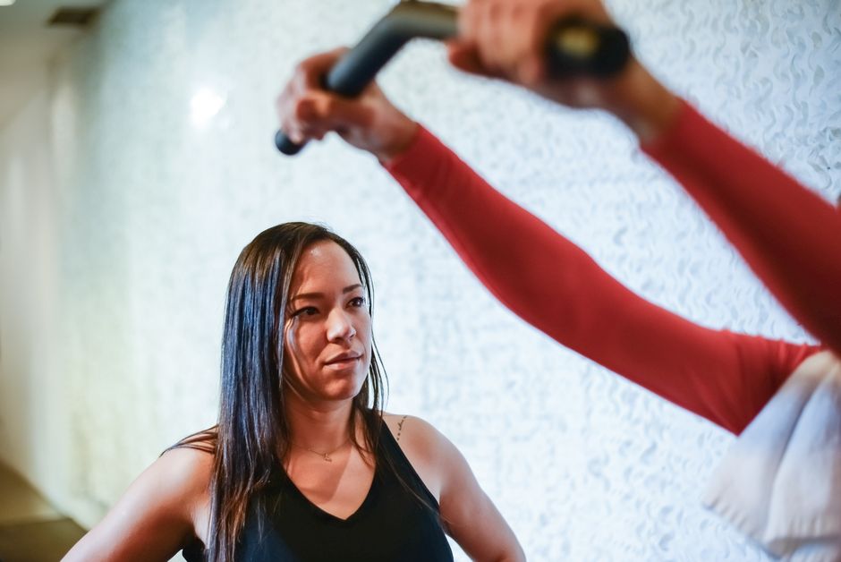 Personal trainer orientando aluno durante treino em academia